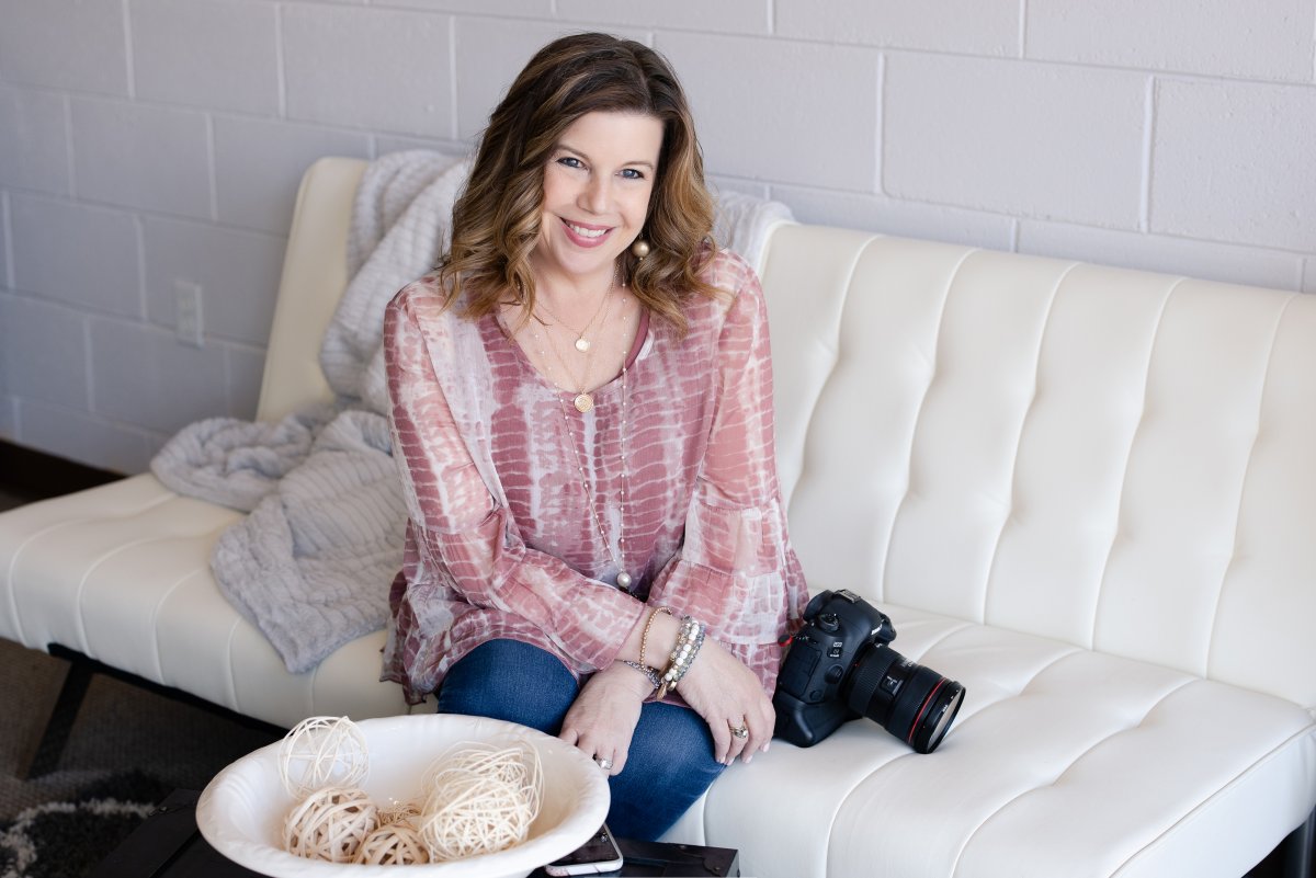 Justine at studio sitting on sofa. She is a wedding photographer in Bismarck ND with studio in Hazen